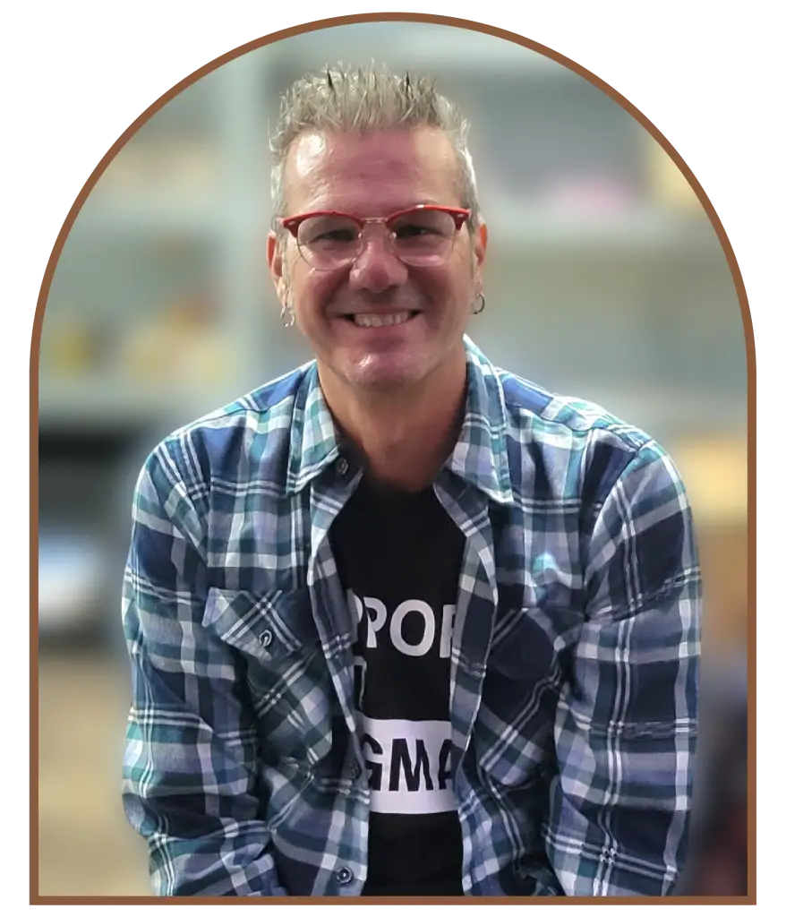 Man with spiky white hair wearing plaid shirt and sunglasses.